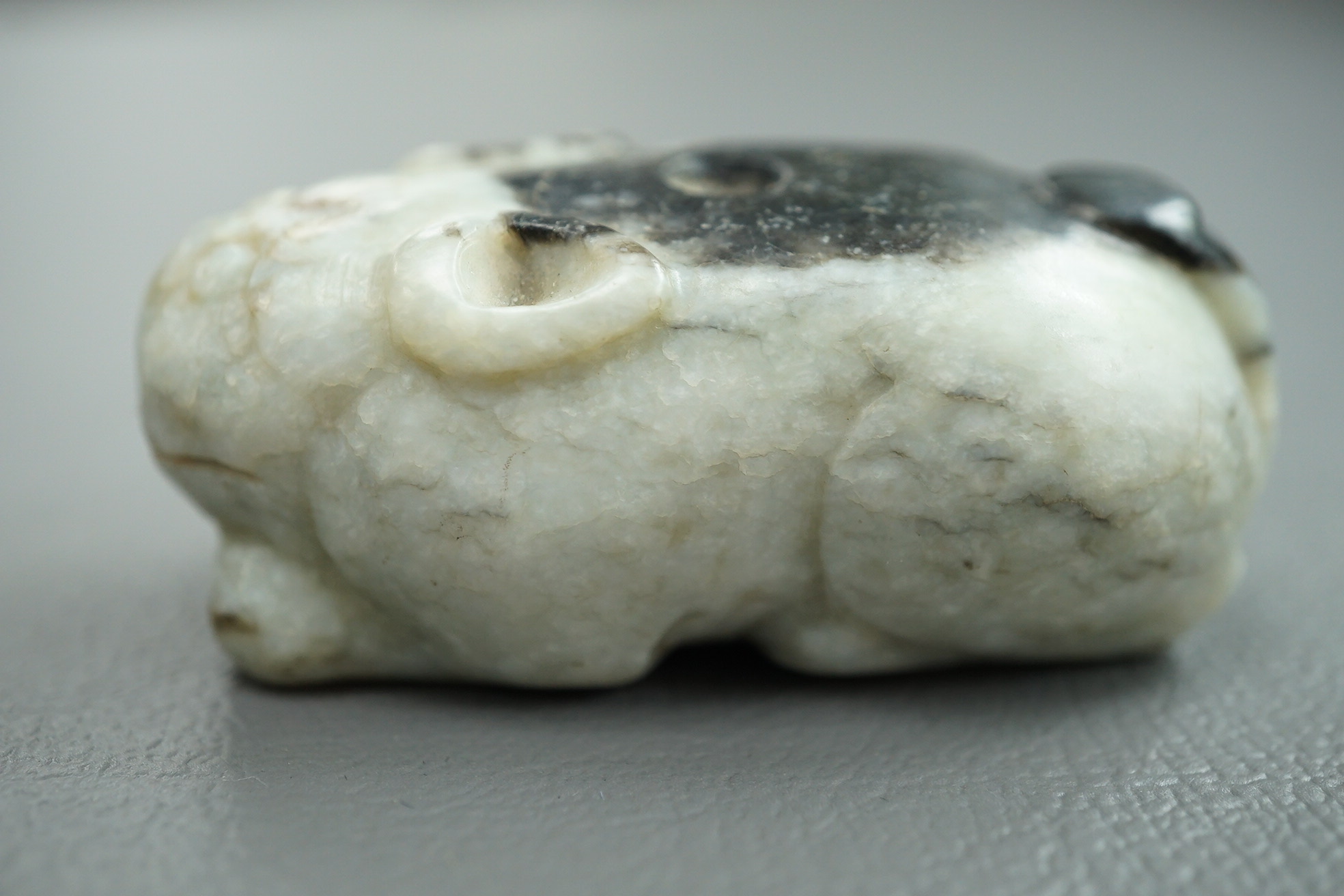 A Chinese white and black jade figure of a recumbent tiger, Song dynasty